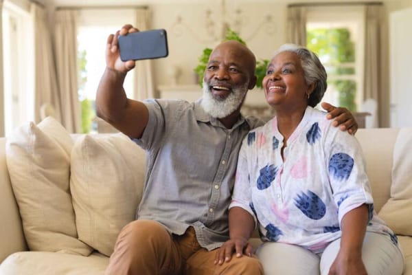 Two seniors sharing a joyful moment on a sofa