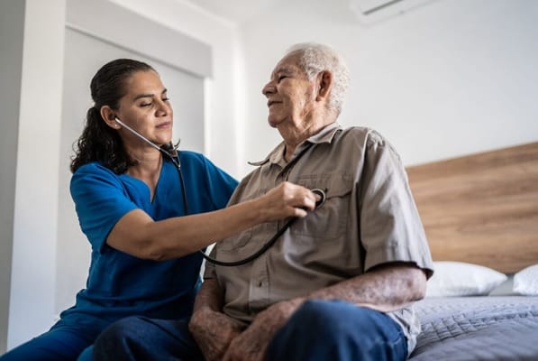 Healthcare staff attending to an elderly resident in a room
