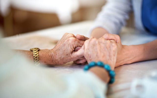 Two hands being held in a caring gesture