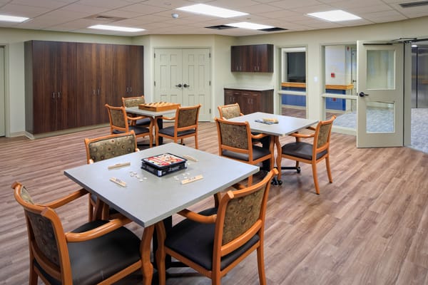 Bright common area with tables and chairs for activities