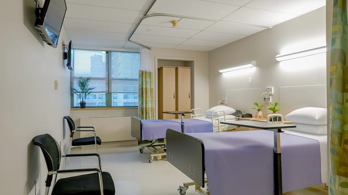 Neat twin resident rooms with medical beds and plants