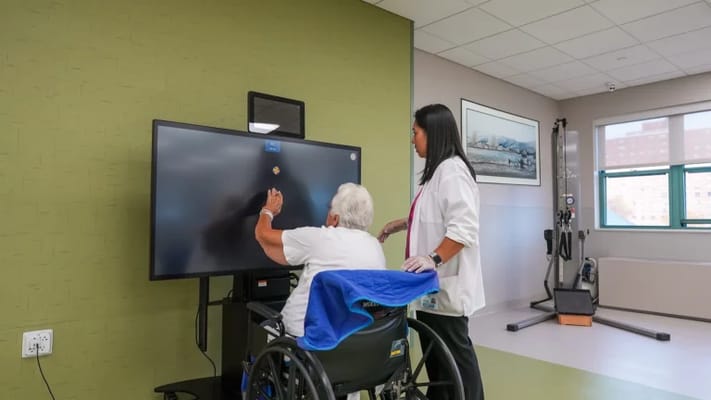 Staff assisting a resident with interactive technology