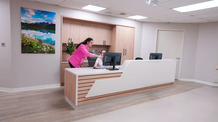 A staff member at the reception desk in a modern lobby