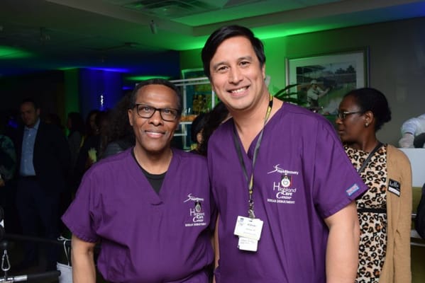 Two staff members posing together at a lively event