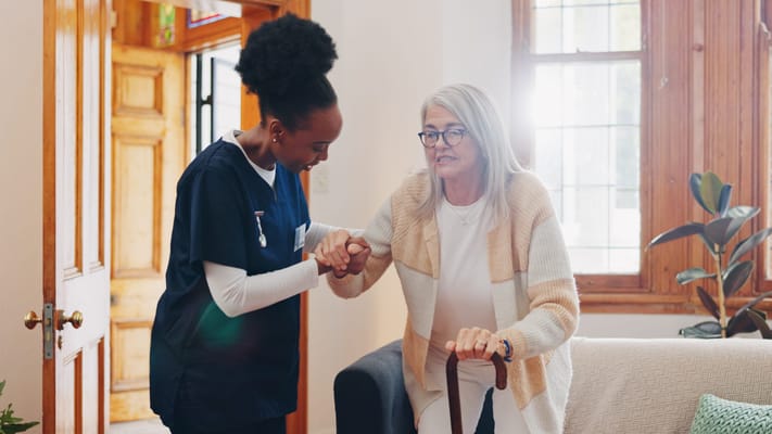 Caregiver assisting a resident in an interior space