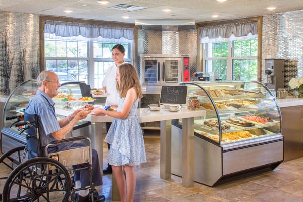 Senior resident receiving food in a dining area