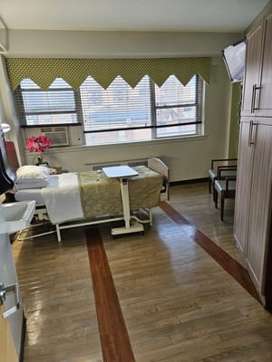 A view of a private resident room with a bed and furniture