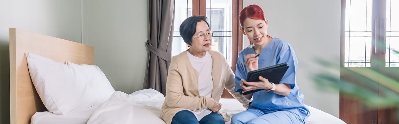Caregiver assisting a resident with a tablet