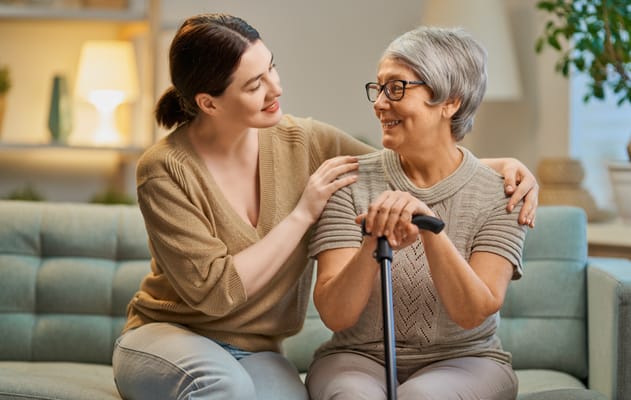 A caregiver and resident sharing a warm moment on a couch