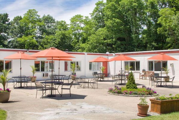 Outdoor seating area with orange umbrellas and greenery