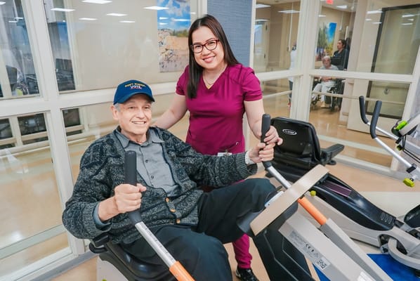 Resident participating in physical therapy with staff member