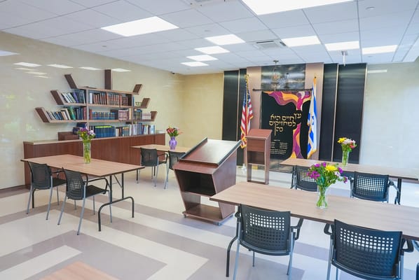 Common area with tables and chairs, flowers on display