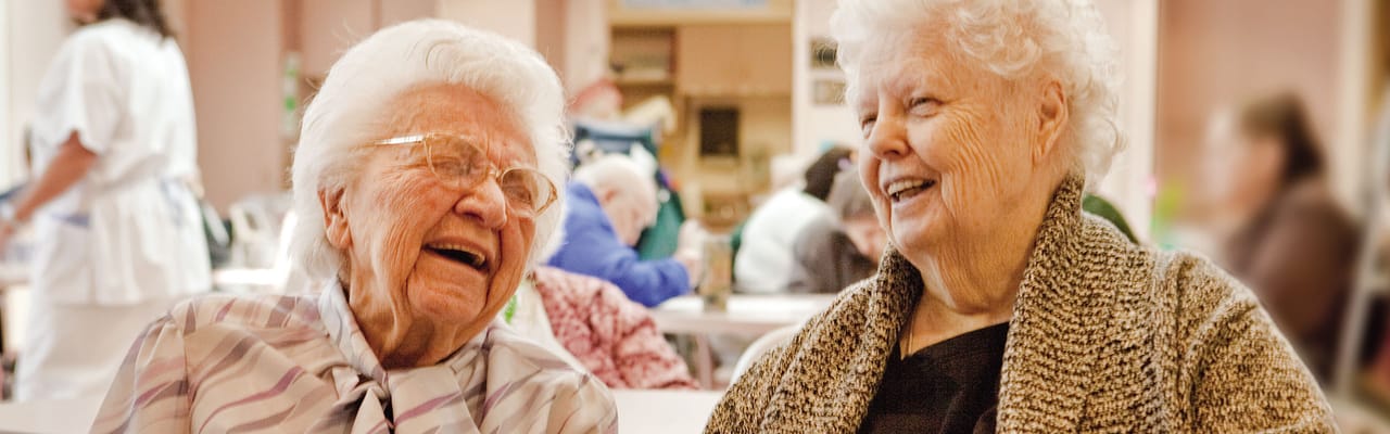 Two smiling residents enjoying a conversation