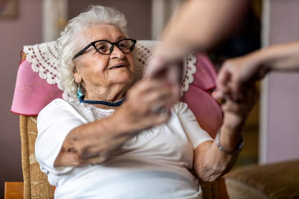 An elderly woman conversing with a caregiver