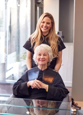 A resident receiving a hair treatment from a stylist