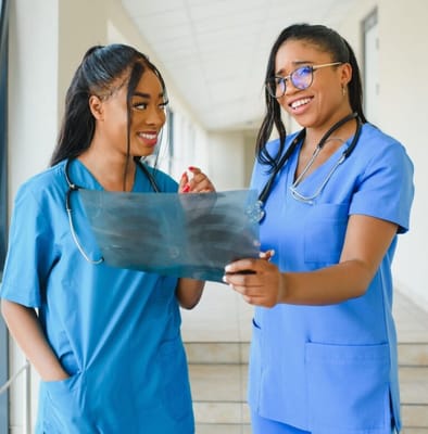 Two healthcare staff discussing in a hallway