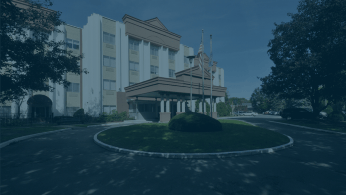 Entrance of a senior living facility with flags