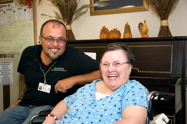 Staff member and resident smiling together in a common area