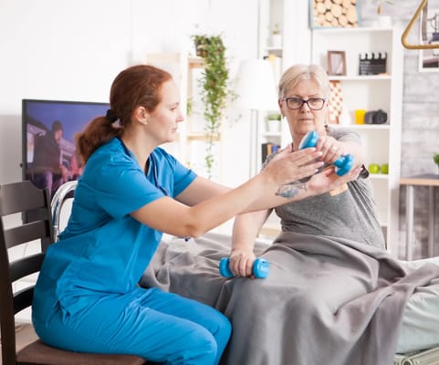 Therapist assisting a senior with light weights