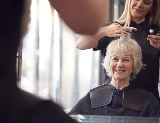 Resident receiving a haircut in a salon