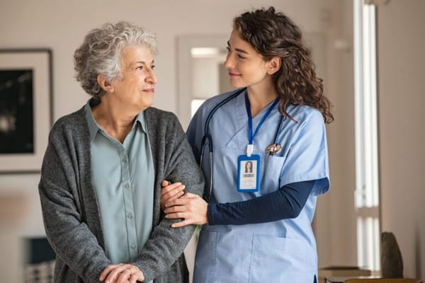 A caregiver interacting with a resident in a bright room