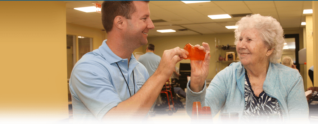 Staff member engaging with a resident in an activity room