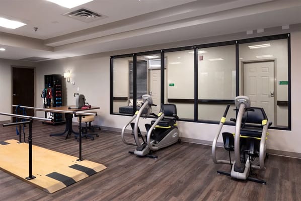 Therapy room with exercise equipment and ballet bar