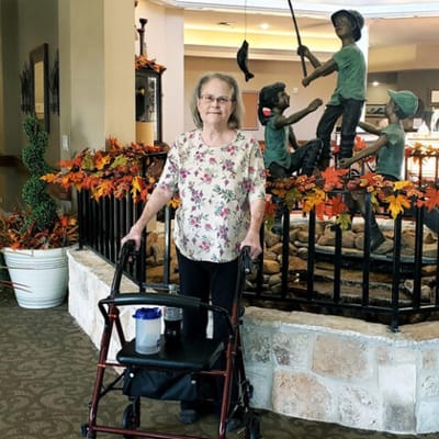 Resident using a walker in a decorated common area