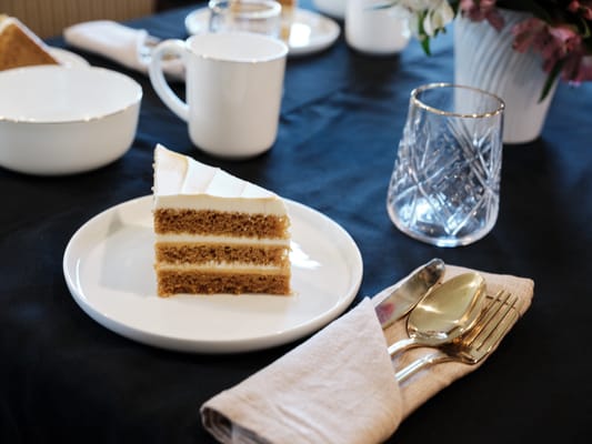 A slice of cake on a dining table setting