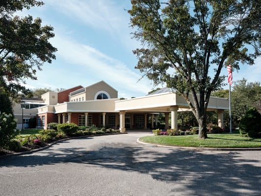 Front entrance of a senior living facility with landscaped garden