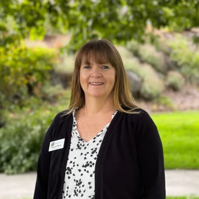 Staff member smiling in a garden area
