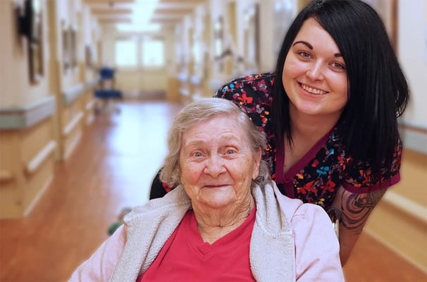 A caregiver with a resident in a hallway