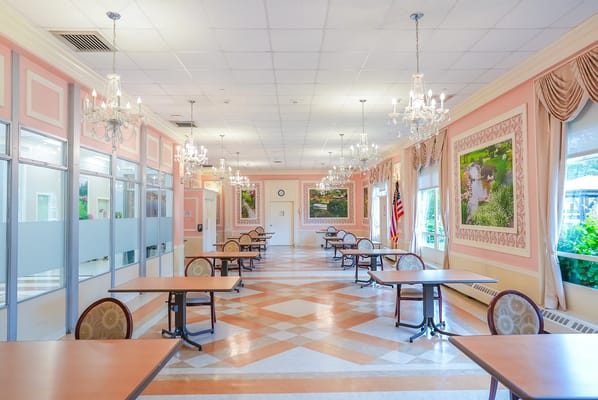 Bright dining area with several tables and chandeliers