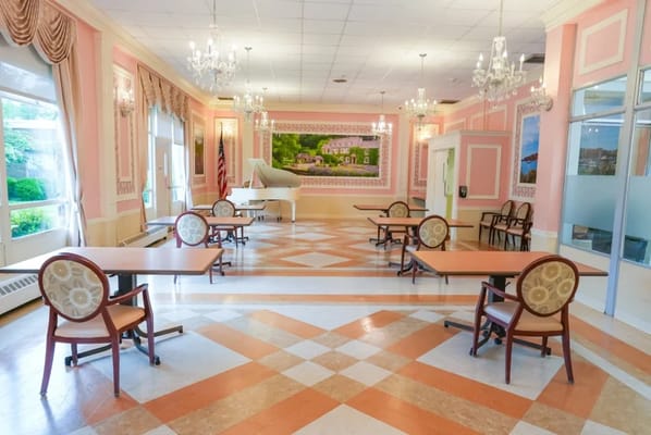 Bright interior of a common area with tables and piano