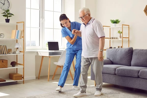 Healthcare staff assisting a resident in a cozy room
