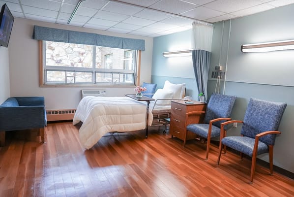 Cozy private resident room with a bed and chairs