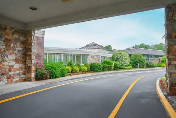 Entrance view of a senior living facility with landscaped gardens