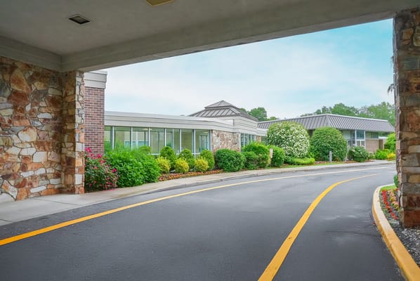 Entrance view of a senior living facility with landscaped gardens