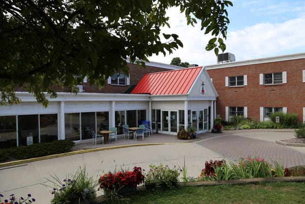 Building exterior with red roof and flower beds