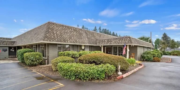 Exterior view of a senior living facility surrounded by greenery