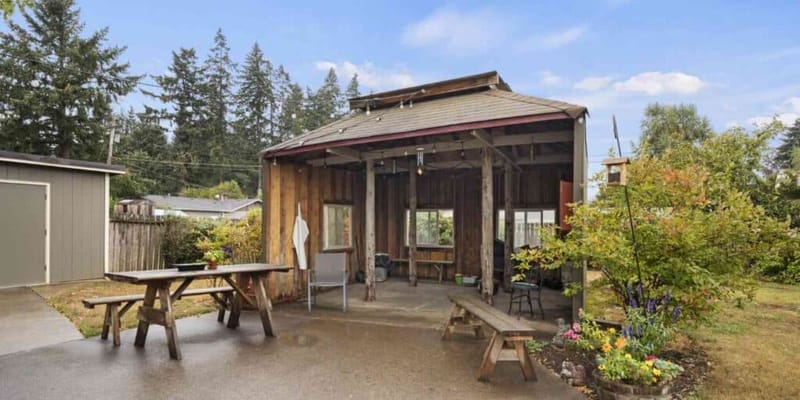 Outdoor covered space with picnic tables and plants