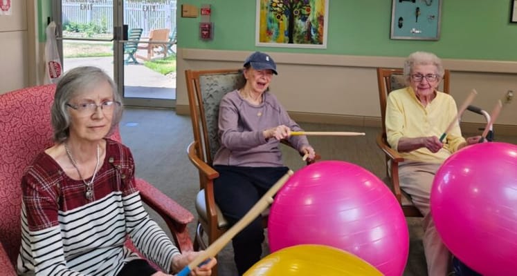 Residents engaged in a lively music activity with exercise balls