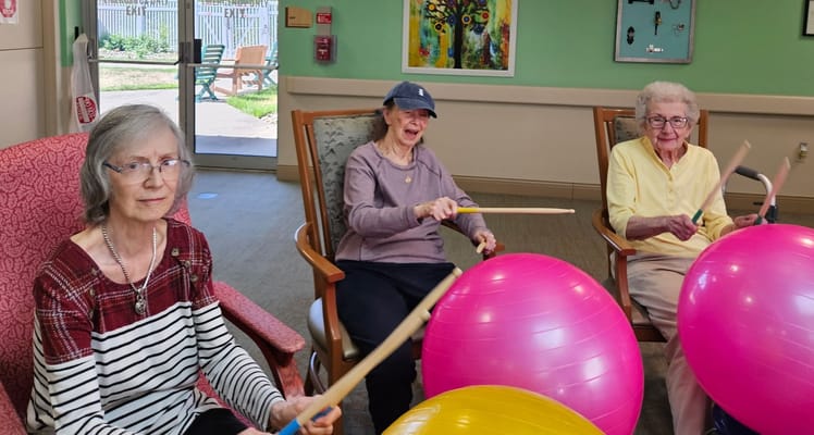 Residents engaged in a lively music activity with exercise balls