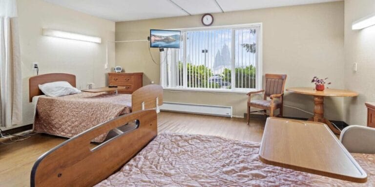 Shared resident room with two beds and a window view