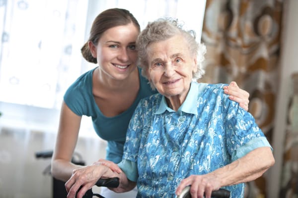 A caregiver with a senior resident smiling together