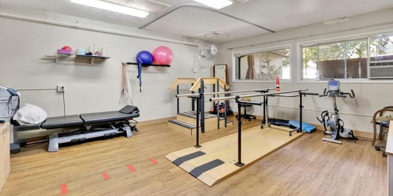 Physical therapy room with exercise equipment and therapy tools