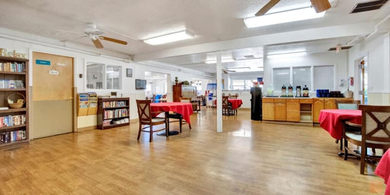 Bright common area with red tablecloths and bookshelves
