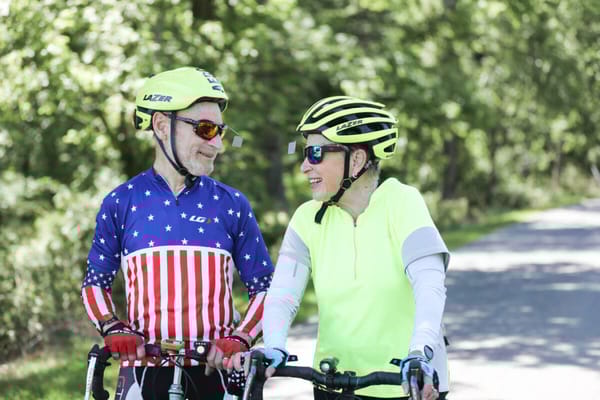 Two seniors enjoying a bike ride in a park