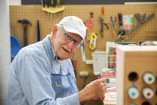 A senior man working on a craft project in a workshop