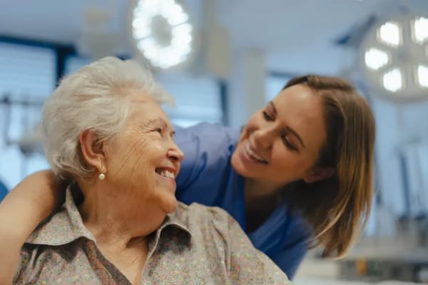 Care staff smiling with a resident in a care facility